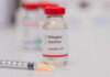 Vial of shingles vaccine next to a syringe