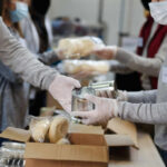 Pantry Staples Fuel Cancer Surge Volunteers packaging food items in a community service setting