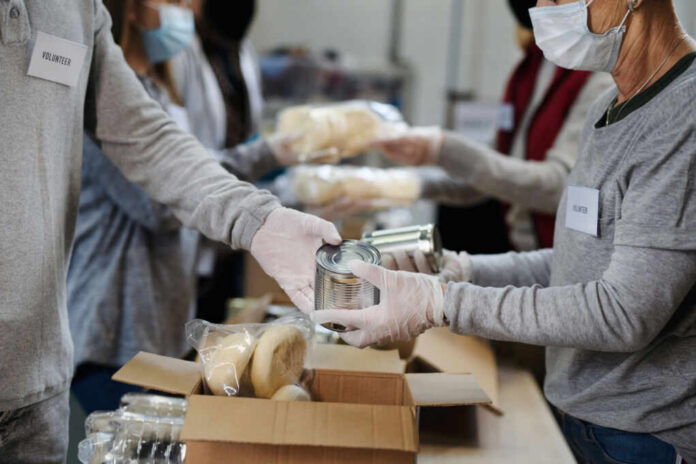 shutterstock1841077360jpg Volunteers packaging food items in a community service setting