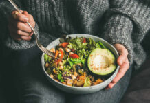 The Hidden Danger of Fiber Overload A person holding a bowl of colorful salad with avocado and greens