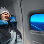 Why Bizarre Dreams Could Mean Better Rest A passenger sleeping on an airplane with headphones and an eye mask