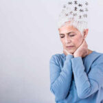 Aging Anxiety: The Hidden Health Threat Elderly woman with a unique hairstyle made of puzzle pieces, looking thoughtful