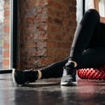 Person using a foam roller for stretching in a fitness studio