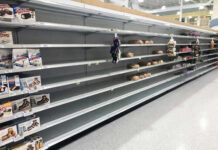 Empty grocery store shelves with a few snack items remaining