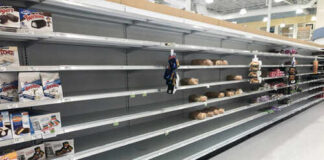 Empty grocery store shelves with a few snack items remaining