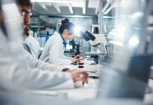 Scientists working in a laboratory with microscopes and test tubes