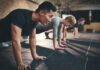 Why Your Fitness Is Stuck: The Real Culprit Group of individuals performing push-ups in a gym