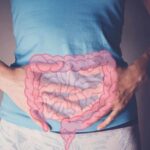 Gut Medications DOUBLE Death Risk – Shocking Study Person holding their stomach with a graphic of intestines overlayed