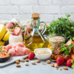 Yogurt and Cancer: The Truth Revealed A variety of fresh foods including fruits, vegetables, and oils arranged on a table
