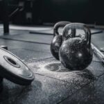 The Startling Science Behind Gym Dropouts Kettlebells and weights on a gym floor with chalk dust