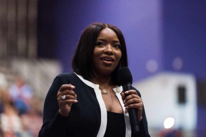 A woman speaking into a microphone at a conference