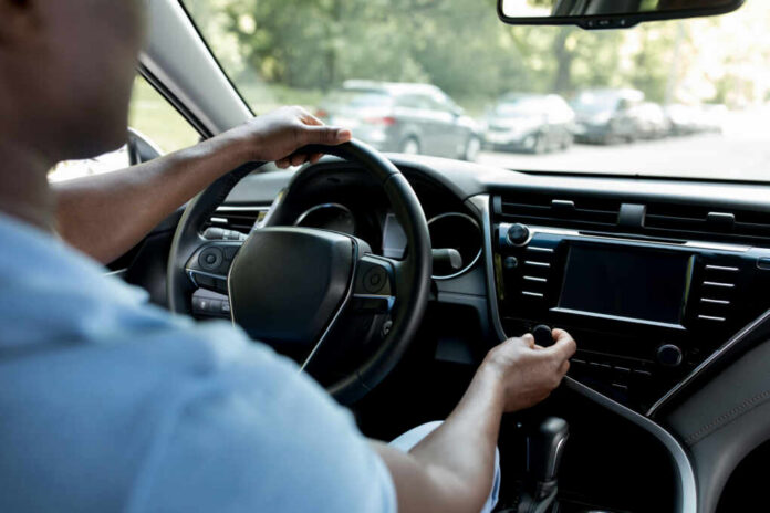 shutterstock_2019434639 Drivers hands on the steering wheel inside a car