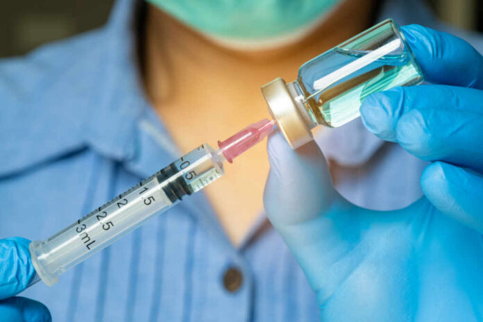 shutterstock_2466644039 Healthcare professional preparing a syringe from a vial
