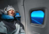 Snoring’s Hidden Heart Attack Trap A passenger sleeping on an airplane with headphones and an eye mask
