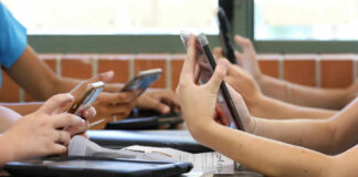 Students in a classroom using smartphones for a group activity