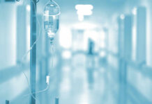 Why Cancer Treatments Stop Working For Many Patients IV drip in a hospital corridor with a blurred background