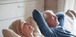 Two adults relaxing on a couch with eyes closed