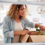 Woman unpacking groceries into a refrigerator