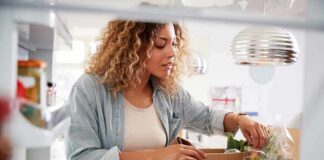 Woman unpacking groceries into a refrigerator