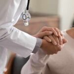 Doctor holding patient’s hand in support