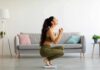 Woman in activewear kneeling on a bathroom scale