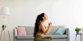 Woman in activewear kneeling on a bathroom scale