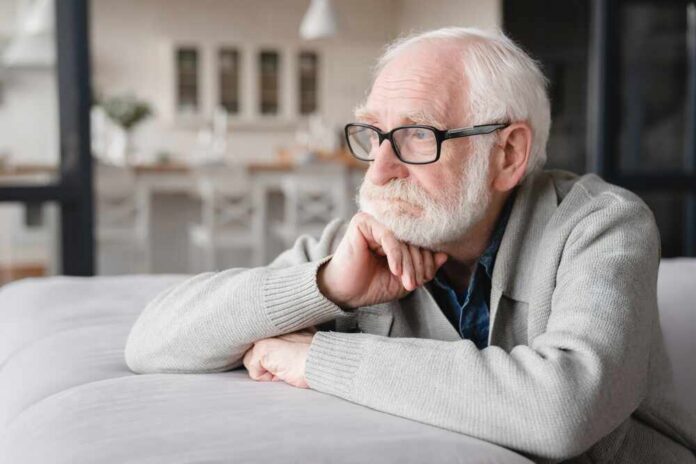 Sad,Tired,Ill,Sick,Lonely,Disappointed,Caucasian,Old,Elderly,Senior Elderly man with glasses resting his chin on his hand, looking thoughtfully