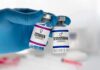 Gloved hand holding estrogen and testosterone vials