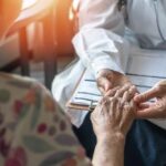 Hidden Arthritis Triggers — Early Clues, Big Stakes A doctor holding the hand of an elderly patient during a consultation