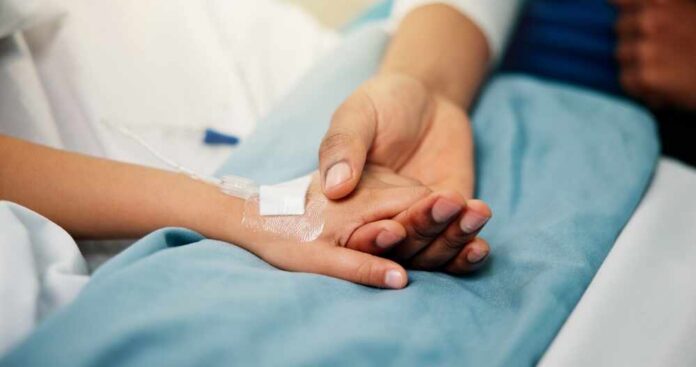 Hospital,,Holding,Hands,And,Parent,With,Child,In,Bed,For A patient holding hands with a loved one in a hospital setting