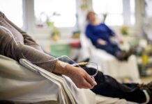 When Cancer Spreads More: Midlife vs Old Age? Patient arm with IV line in a hospital chair