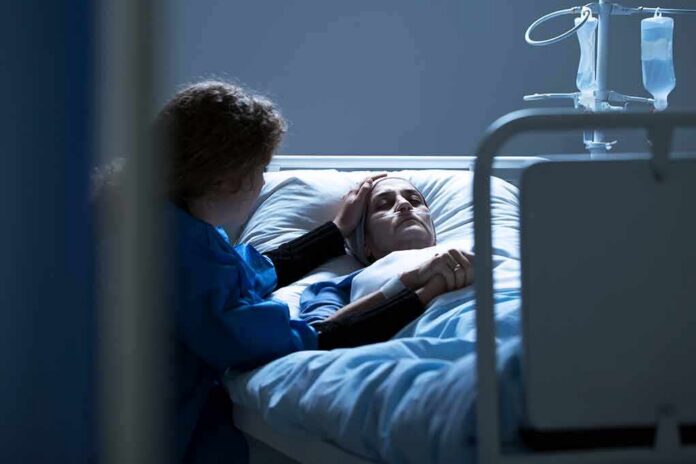 Patient in hospital bed with visitor holding their hand