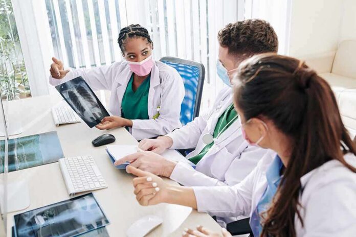 shutterstock_1779923279 Doctors reviewing chest X-ray at a workstation