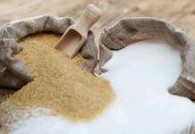 Brown and white sugar in burlap sacks with wooden scoop