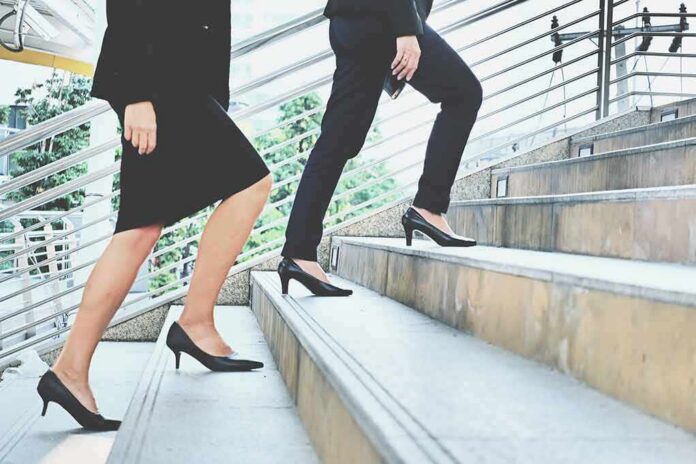 Two businesspeople in formal wear walking up stairs