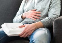 Cancer Flags Ignored in Everyday Food Packaging Person holding takeout container while touching stomach