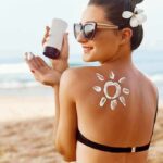 Woman applying sunscreen on beach