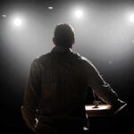 Career Safety Myth Exposed Speaker on stage under bright spotlights