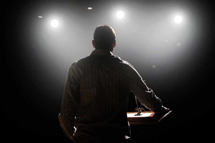 Speaker on stage under bright spotlights