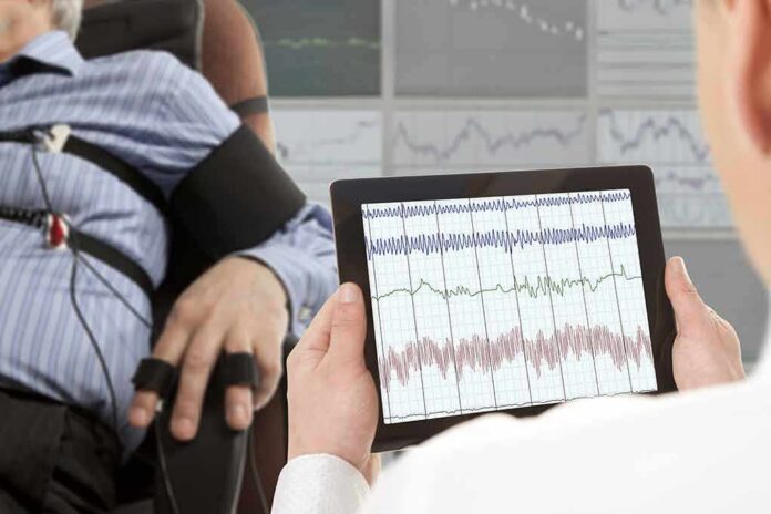 Technician reviews polygraph readings on a tablet beside a seated subject