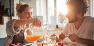Couple eating breakfast with orange juice at a sunlit table