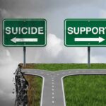 Road splitting at a cliff with signs pointing to suicide and support