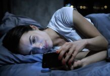 How to easily quit your phone addiction Woman lying in bed looking at a smartphone