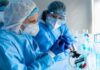 Ebola Can Persist in Semen for Months After Recovery Scientists in protective gear working with a syringe in a laboratory