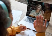 Work-From-Home Trap Exposed Student in headphones waving at a person on a laptop video call