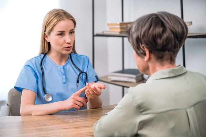 Healthcare professional consulting with an older woman at a desk