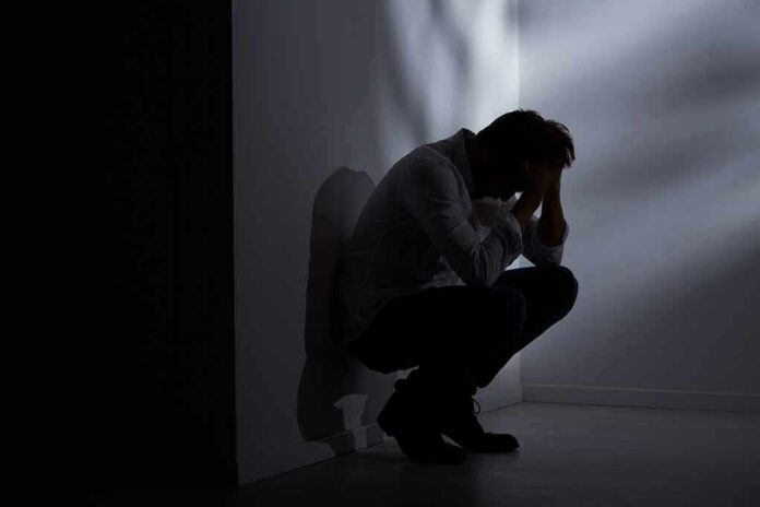 Silhouetted person crouching in a dimly lit corner